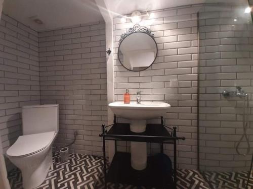 a white bathroom with a sink and a toilet at Speri's Loft in Preveza