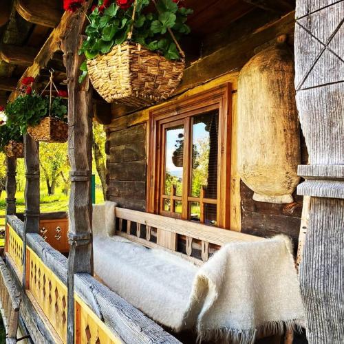 a porch of a log cabin with a window at Casa din Susani in Călineşti