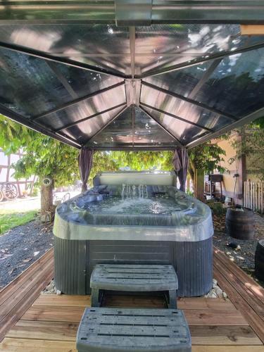 a hot tub sitting under a pergola at Chambre indépendante n1 - Bretzel et Bergamote in Richtolsheim