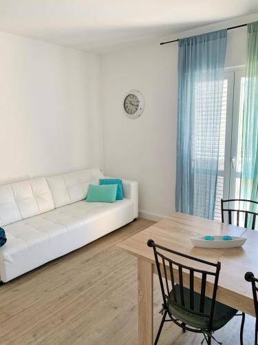 a living room with a white couch and a table at Apartmani Stupin Čeline in Podglavica