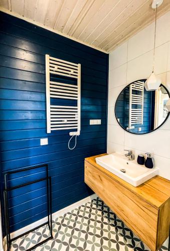 a blue bathroom with a sink and a mirror at Błękitny Kopań in Kopań