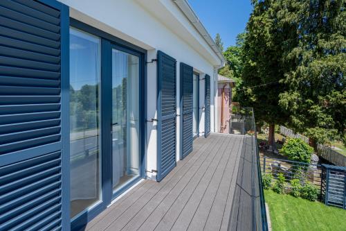 a wooden deck with blue shutters on a house at Rózsabors Hévíz in Hévíz