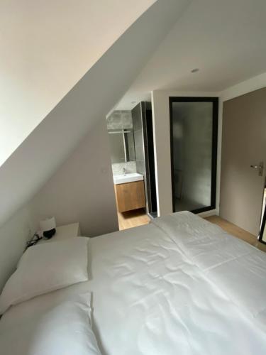 ein großes weißes Bett in einem Schlafzimmer mit Bad in der Unterkunft Appartement vue Port in Boulogne-sur-Mer