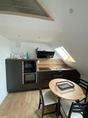 une cuisine avec une table, des chaises et un comptoir dans l'établissement Appartement vue Port, à Boulogne-sur-Mer