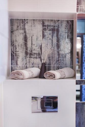 a shelf with three rolled towels and a vase on it at Apartament Podwale in Łańcut