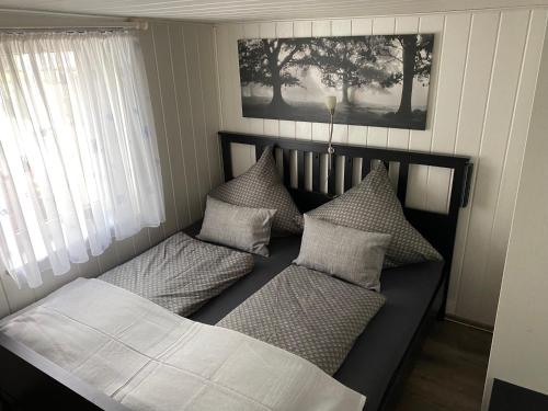 un letto con cuscini sopra in una camera da letto di Waldidyll a Plötzky