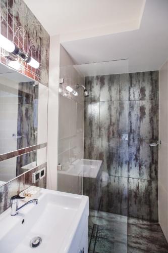 a white bathroom with a sink and a shower at Apartament Podwale in Łańcut