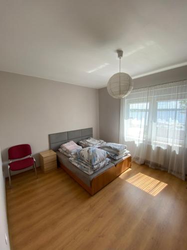 sypialnia z łóżkiem i czerwonym krzesłem w obiekcie Apartament U rybaka w mieście Stężyca
