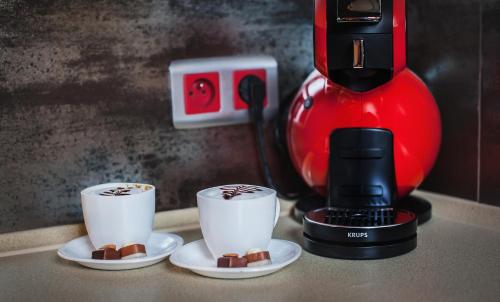 a coffee maker with two cups of coffee on a counter at Apartament Podwale in Łańcut