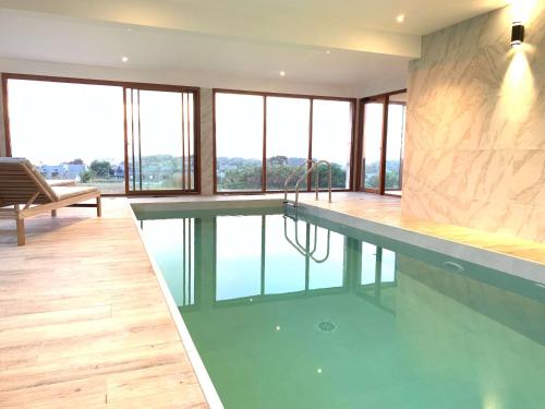 una piscina en una casa con agua. en Les Villas d'Onalou - Bugueles en Port-Blanc