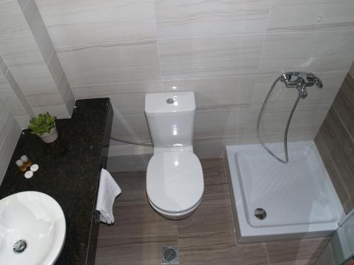 a bathroom with a white toilet and a sink at Kavala Beach Hotel apartments in Iraklitsa