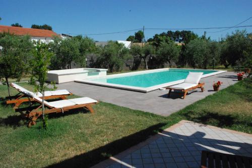 uma piscina com duas espreguiçadeiras em Paraiso em Mafalda