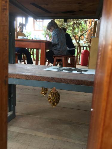 a woman sitting at a table with a pineapple on it at Indano Art Lodge in Lamas