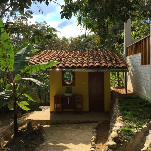 a small yellow house with a tile roof at Indano Art Lodge in Lamas