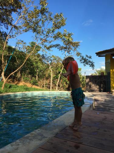 a young boy standing next to a swimming pool at Indano Art Lodge in Lamas