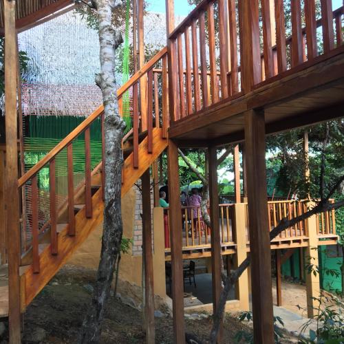 a wooden house with people sitting on the deck at Indano Art Lodge in Lamas