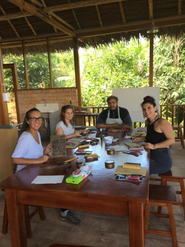 a group of people sitting around a wooden table at Indano Art Lodge in Lamas