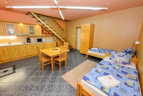 a room with a kitchen and a table with a bed at Tinódi Fogadó in Sárvár