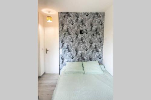 un lit dans une chambre avec un mur dans l'établissement Charmant appartement avec vue sur les montagnes, à Annecy