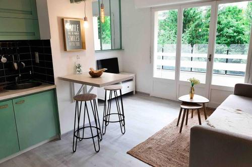 une cuisine avec une table et des tabourets dans une pièce dans l'établissement Charmant appartement avec vue sur les montagnes, à Annecy