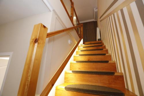 a stairway with wooden steps with a green rug at Tinódi Fogadó in Sárvár