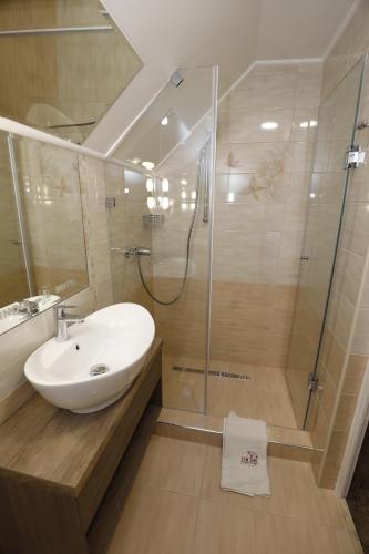 a bathroom with a sink and a shower at Tinódi Fogadó in Sárvár
