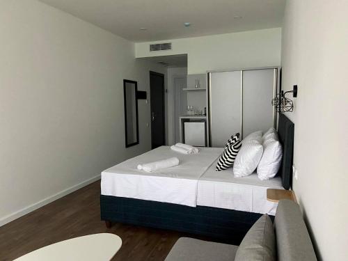 a bedroom with a large bed and a couch at Cabo Verde Boutique Hotel in Batumi