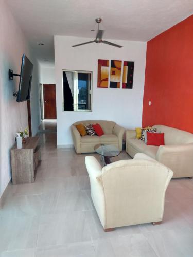 a living room with two couches and a flat screen tv at Casa Esencia in Cozumel