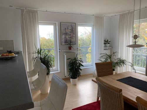 a dining room with a table and chairs and windows at Boardinghouse Saargau in Überherrn