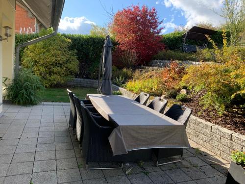 a table and chairs with an umbrella on a patio at Boardinghouse Saargau in Überherrn