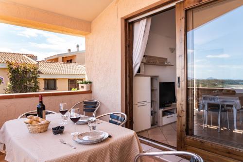 una mesa con copas de vino en el balcón en Villa Laura en Villaputzu