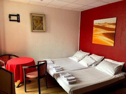 a bed in a room with a red wall at Hotel de Savoie in Annecy