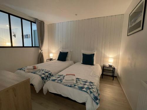 two twin beds in a room with a window at Maison L'Aiguille - 2 appartements, 5 chambres et table d'hôtes au pied de la montagne à la station de Laye in Laye