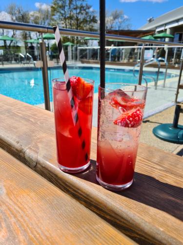 two drinks sitting on a table next to a pool at The Hideaway in Grange Over Sands