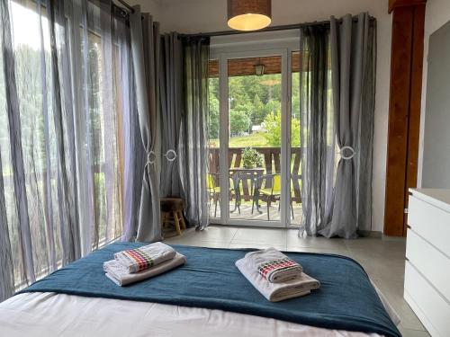 a bedroom with a bed with two pillows on it at Maison L'Aiguille - 2 appartements, 5 chambres et table d'hôtes au pied de la montagne à la station de Laye in Laye