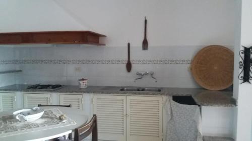 - une cuisine avec un évier et un comptoir dans l'établissement Country House La Caletta Carloforte, à Carloforte