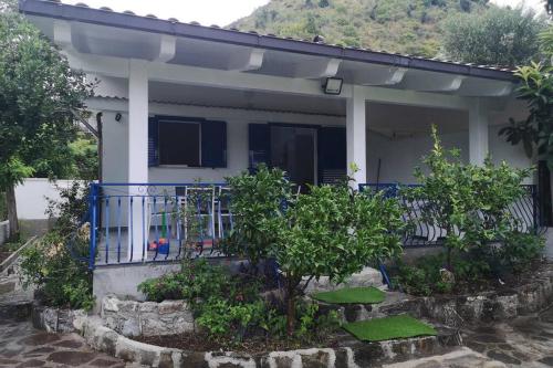 a small white house with a blue balcony at Villa Cilento Mare, bellissima con ampio giardino in Capitello