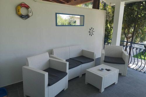 a patio with wicker chairs and a table at Villa Cilento Mare, bellissima con ampio giardino in Capitello