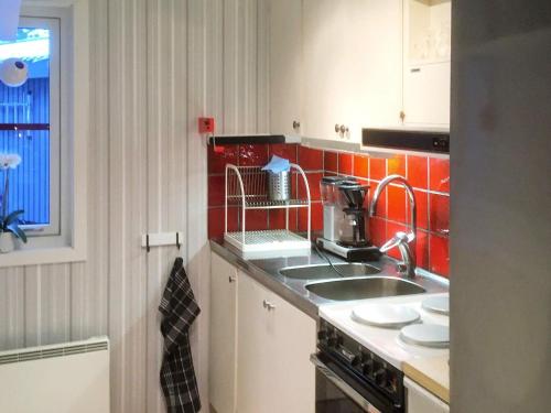 a kitchen with a sink and red tiles at Holiday home SÄRNA in Särna
