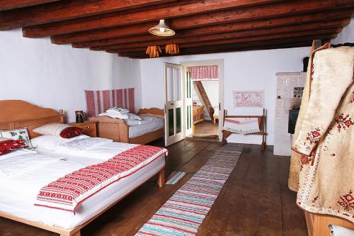 a bedroom with two beds and a wooden ceiling at La Hansi in Crit in Criţ
