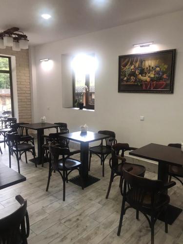 a restaurant with tables and chairs and a painting on the wall at Hotel Dykyi Med in Tatariv