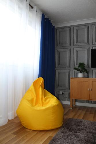 una silla con bolsa de frijoles amarillos en la sala de estar en Glasgow Apartment Cozy and ultramodern en Glasgow