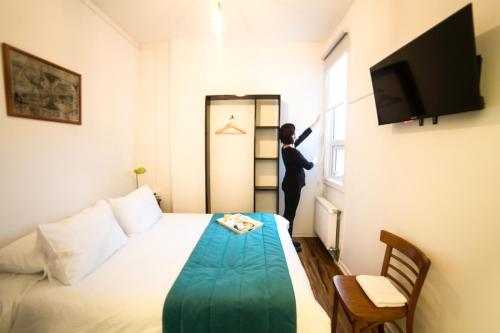 a woman is looking out the window of a hotel room at HOSTAL BOUTIQUE TERRA ANTARCTICA in Punta Arenas