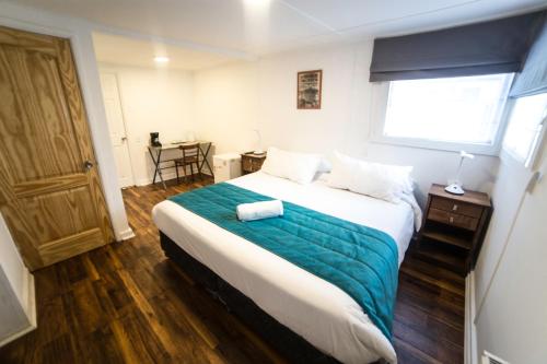 a bedroom with a large bed with a blue blanket at HOSTAL BOUTIQUE TERRA ANTARCTICA in Punta Arenas