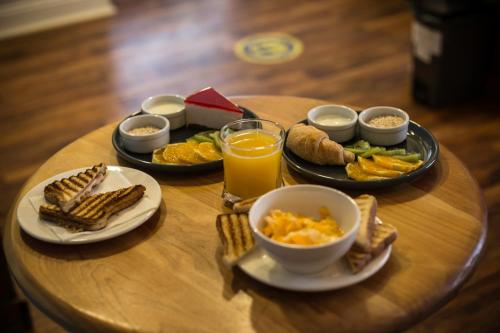 a table topped with plates of breakfast foods and orange juice at HOSTAL BOUTIQUE TERRA ANTARCTICA in Punta Arenas