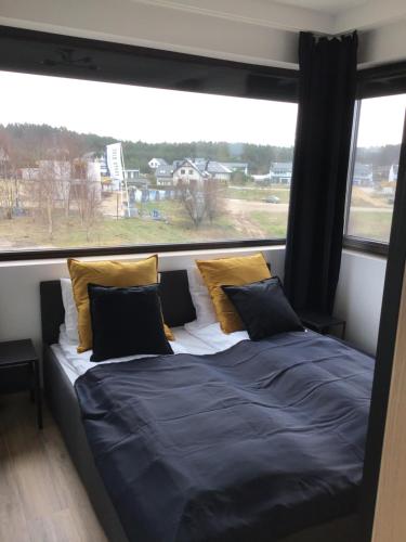 a bed in a room with a large window at Slow Life Apartment Mechelinki in Mechelinki