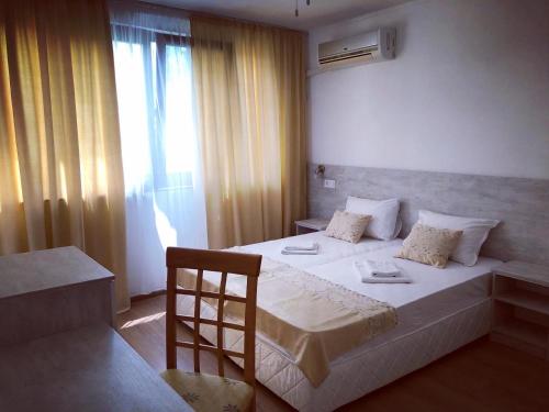 Un dormitorio con una gran cama blanca y una ventana en Family Hotel Southern Nights en Varvara