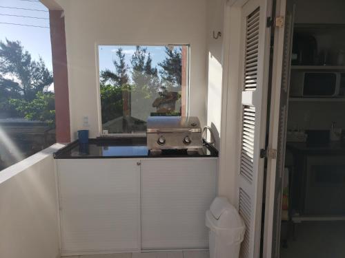cocina con fregadero y ventana en Apartamento na Praia do MORRO BRANCO - CEARÁ - MB06201, en Beberibe