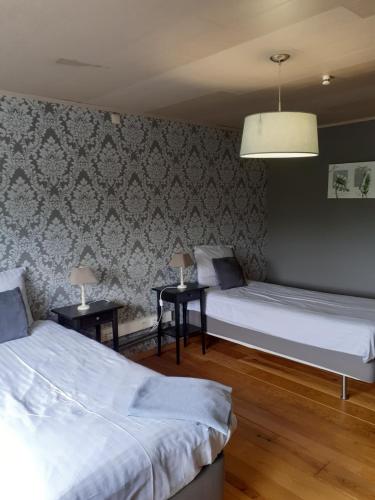 a bedroom with two beds and two night tables at Wenceslas Cobergher Penthouse in Boutersem