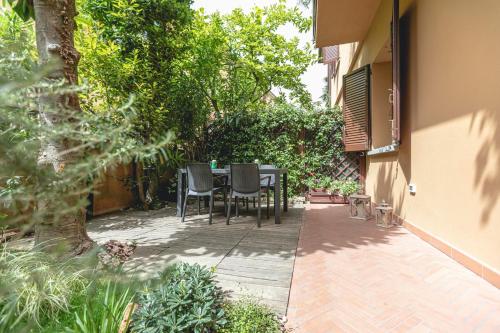 a patio with a table and chairs in a garden at B&B Casa Dodo Luxury in Forlì
